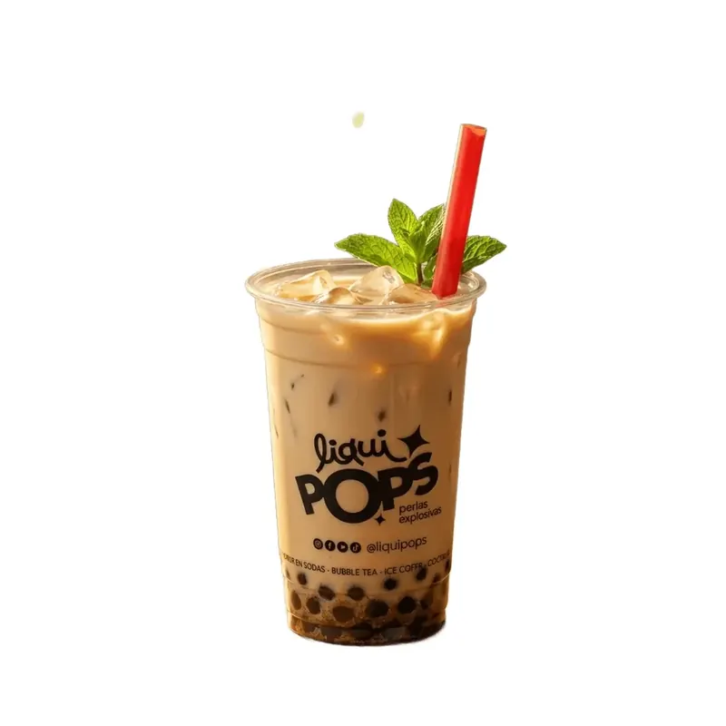 Vaso de bubble tea con leche y hielo con perlas explosivas al fondo y una bombilla roja